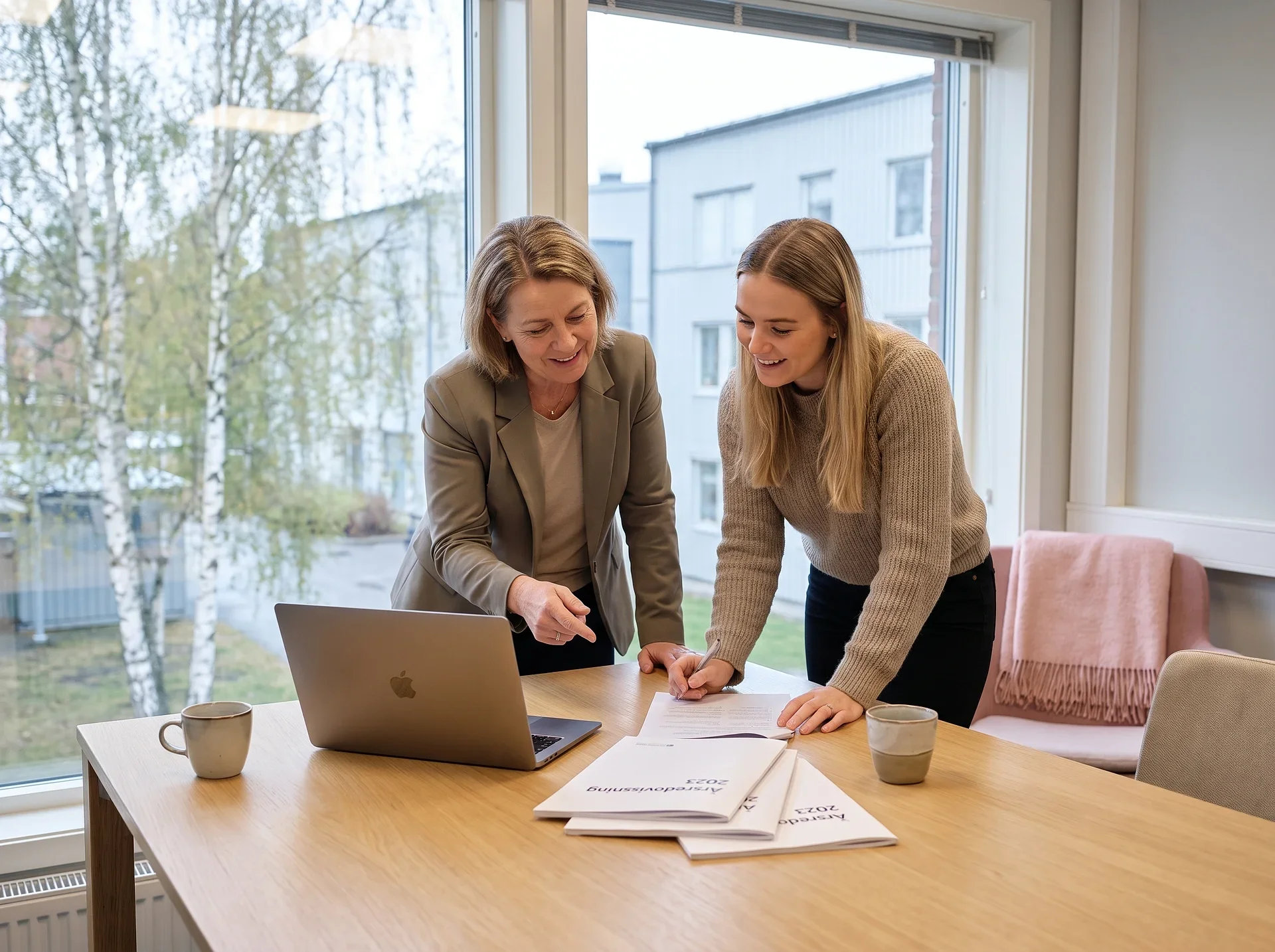 Redovisningskonsult går igenom företagets siffror tillsammans med en kund på kontoret.